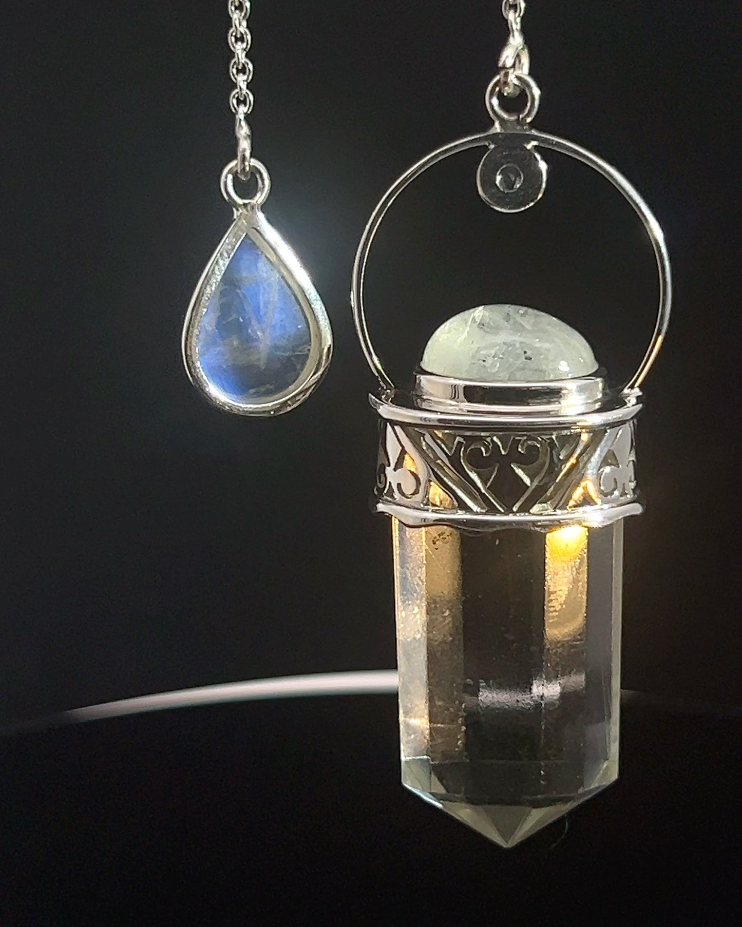 Straight 12 facet Crystal Point w/ Rainbow Moonstone Cabachons Accents and Finger Loop in Fancy .925 Silver Setting w/ Fancy Cutwork Design as a Pendulum