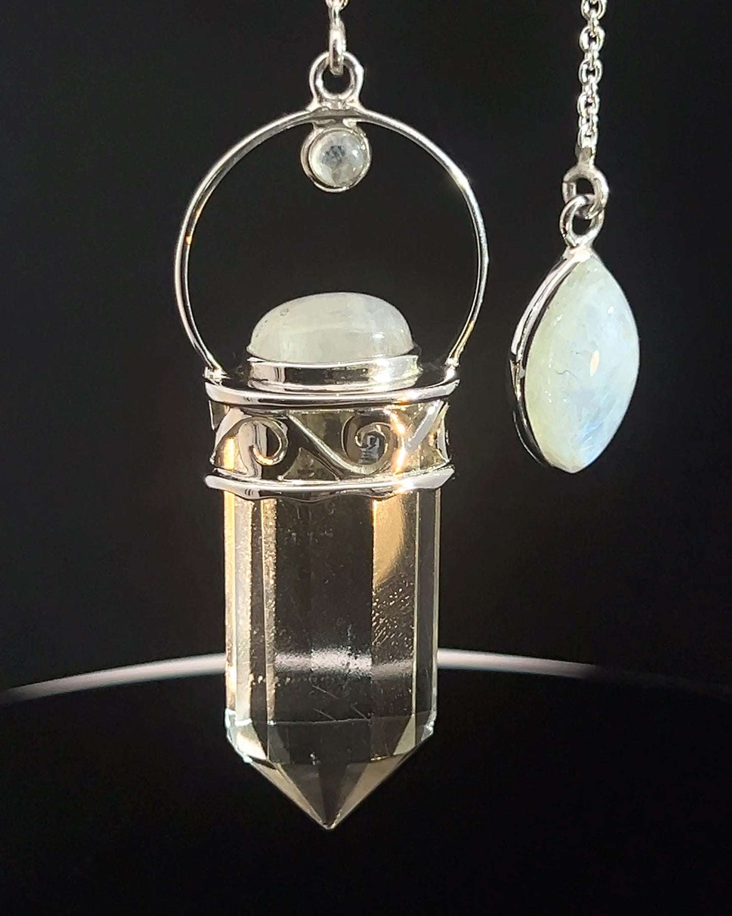 Straight 12 facet Crystal Point w/ Rainbow Moonstone Cabachons Accents and Finger Loop in Fancy .925 Silver Setting w/ Fancy Cutwork Design as a Pendulum