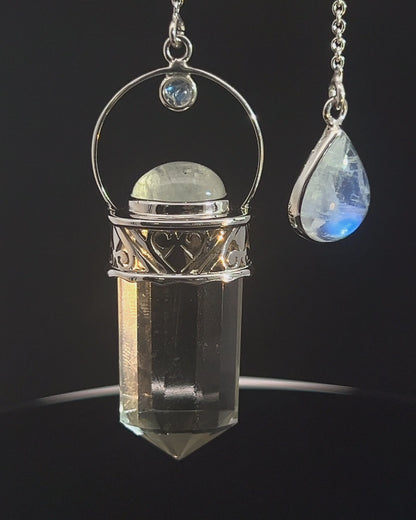 Straight 12 facet Crystal Point w/ Rainbow Moonstone Cabachons Accents and Finger Loop in Fancy .925 Silver Setting w/ Fancy Cutwork Design as a Pendulum